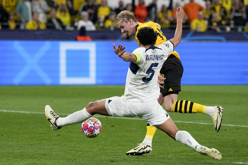 PSG's Marquinhos, front, defenses against Dortmund's Julian Brandt during the Champions League semifinal first leg soccer match between Borussia Dortmund and Paris Saint-Germain at the Signal-Iduna Park in Dortmund, Germany, Wednesday, May 1, 2024. (AP Photo/Martin Meissner)