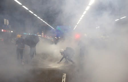 Anti-extradition bill protesters react after tear gas was fire by the police during a demonstration in Tai Wai in Hong Kong