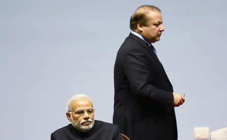 Pakistani Prime Minister Nawaz Sharif walks past his Indian counterpart Narendra Modi (foreground) during the opening session of 18th South Asian Association for Regional Cooperation (SAARC) summit in Kathmandu November 26, 2014. REUTERS/Narendra Shrestha/Pool/Files