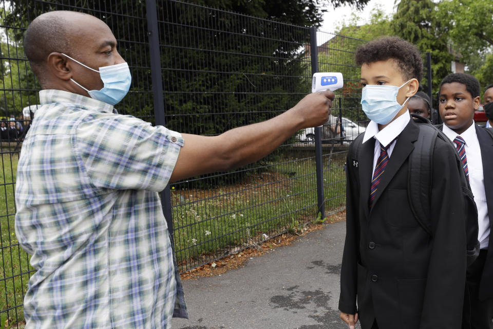 Year seven pupils have their temperature taken by member of support staff Adelaja Balogun, as they arrive for their first day at Kingsdale Foundation School in London, Thursday, Sept. 3, 2020. (Kirsty Wigglesworth/AP Photo)