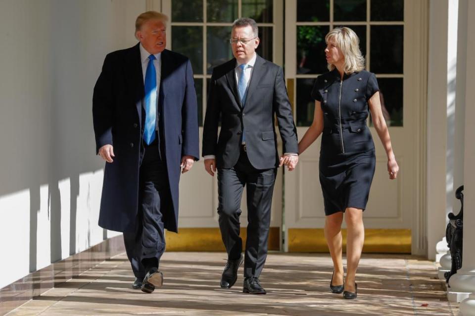 Andrew Brunson and his wife walk with Donald Trump.