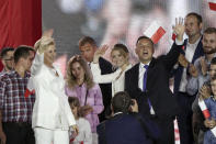 Incumbent President Andrzej Duda, right, his wife Agata Kornhauser-Duda, left, and daughter Kinga, wave to supporters in Pultusk, Poland, Sunday, July 12, 2020. An exit poll in Poland's presidential runoff election shows a tight race that is too close to call between the conservative incumbent, Andrzej Duda, and the liberal Warsaw mayor, Rafal Trzaskowski.(AP Photo/Czarek Sokolowski)