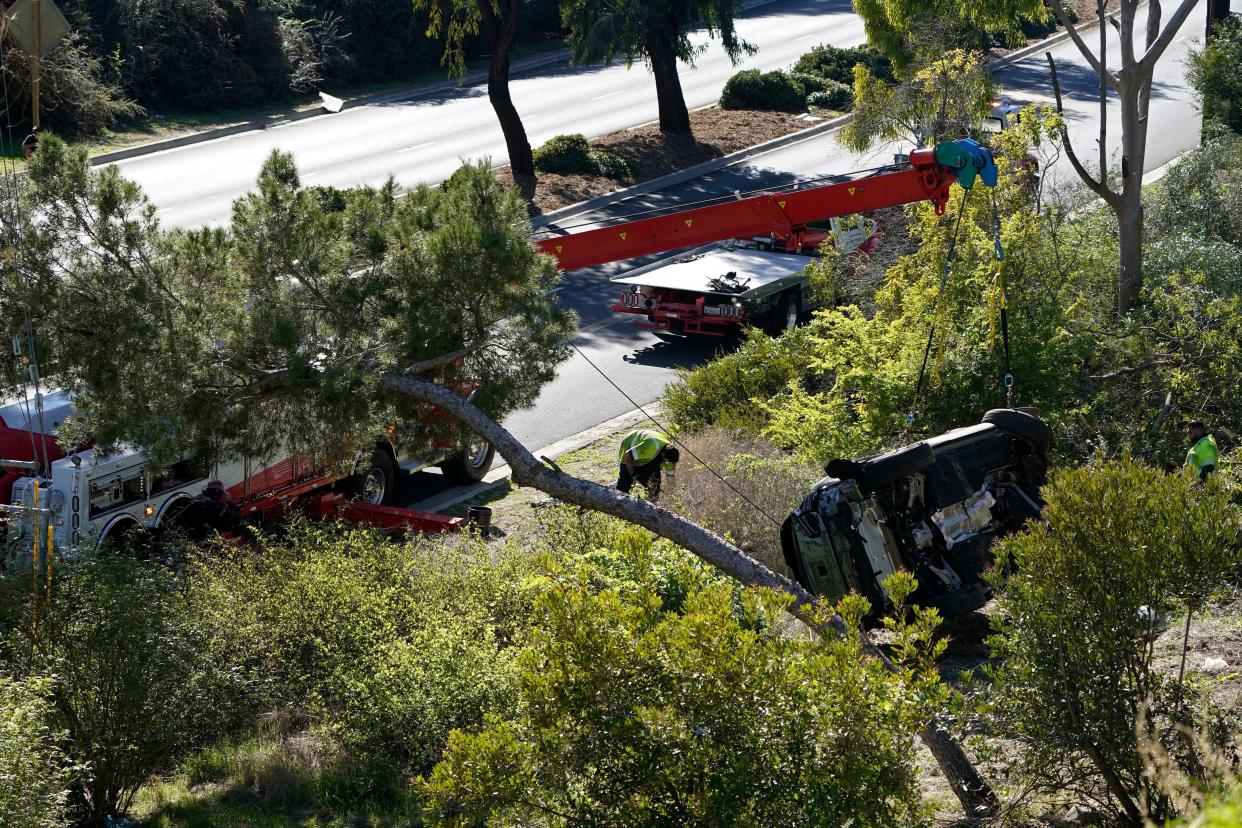 Workers move a vehicle after a rollover accident involving golfer Tiger Woods Tuesday, Feb. 23, 2021, in Rancho Palos Verdes, Calif., a suburb of Los Angeles.