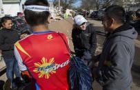 Carrying food and other needed goods, Mary Wittenberg, president of the New York Road Runners, second from right, speaks with a person after handing out produce to a family whose house was heavily damaged in the the hard hit Staten Island borough of New York, Sunday, Nov. 4, 2012, in the wake of Superstorm Sandy. With the cancellation of the New York Marathon, hundreds of runners, wearing their marathon shirts and backpacks full of supplies, took the ferry to hard-hit Staten Island and ran to hard-hit neighborhoods to help. (AP Photo/Craig Ruttle)