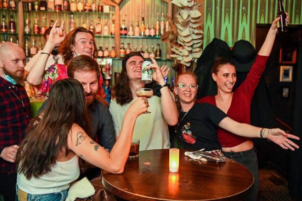 People celebrate in a bar in Melbourne as the city left lockdown overnight. Source: Getty