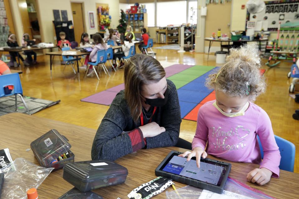Substitute teacher Nikki Winiecki assists kindergarten student Nya Johnson with her tablet for a technology excercise in 2021 at Coolidge Elementary School in Neenah.