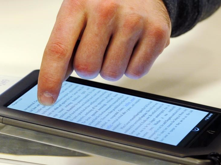 Ben VanderWerp demonstrates the features of a Nook e-reader for a customer at a Barnes and Noble store in Boston, March 18, 2011.  REUTERS/Brian Snyder 