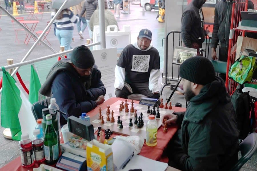 In this screen grab taken from video, Tunde Onakoya, 29- years old, a Nigerian chess champion and child education advocate, left, play a chess game in Times Square, New York, Thursday, April, 18, 2024.A Nigerian chess player and child education advocate is attempting to play chess nonstop for 58 hours in New York City’s Times Square to break the global record for the longest chess marathon and raise $1m for the education of children across Africa. (AP Video/John Minchillo)