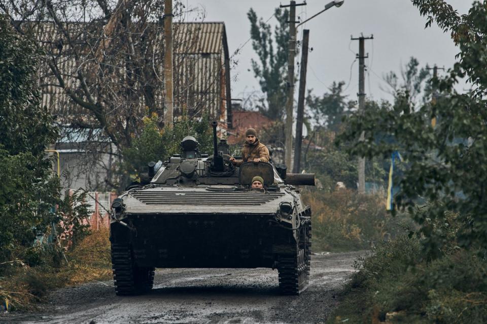 A Ukrainian military vehicle moves on the road in the freed territory in the Kharkiv region (AP)