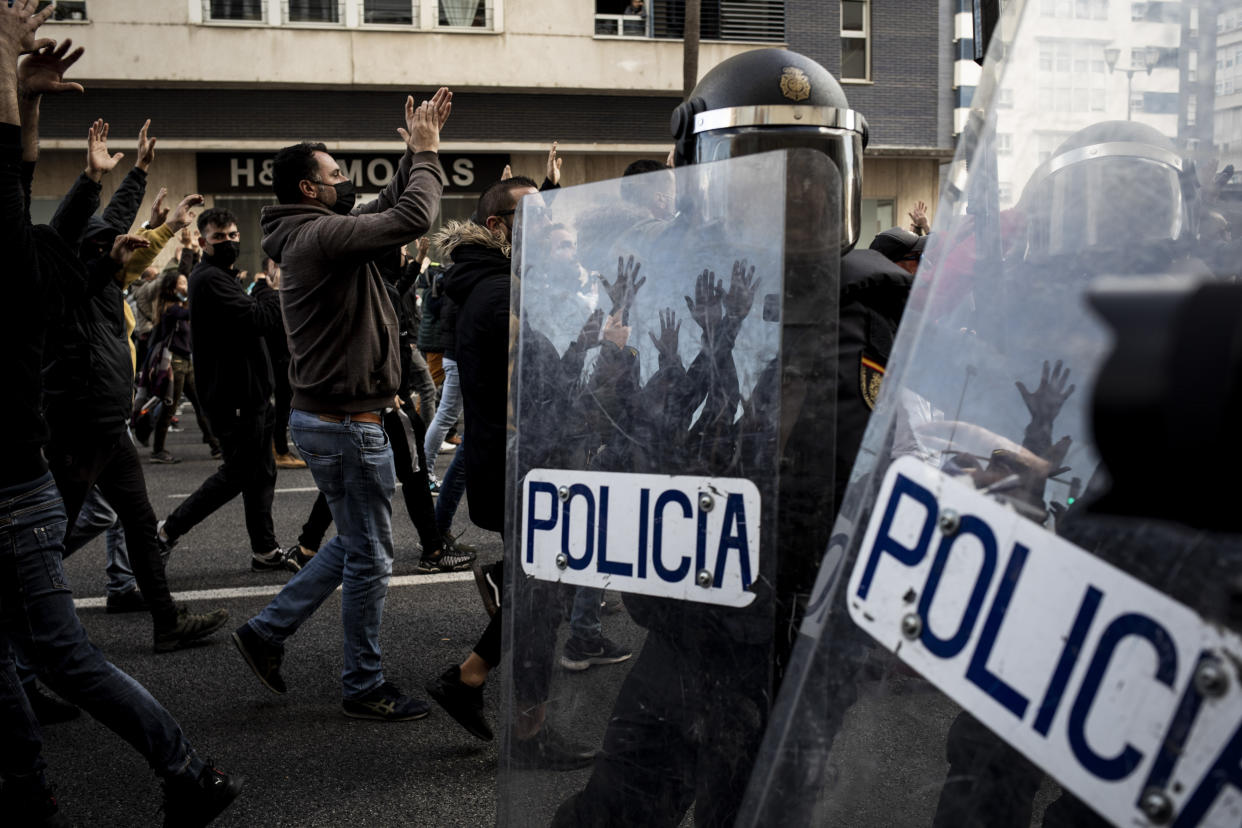 Protesters, left, march during a strike organized by metal workers in Cadiz, southern Spain, Tuesday, Nov. 23, 2021. (AP Photo/Javier Fergo)