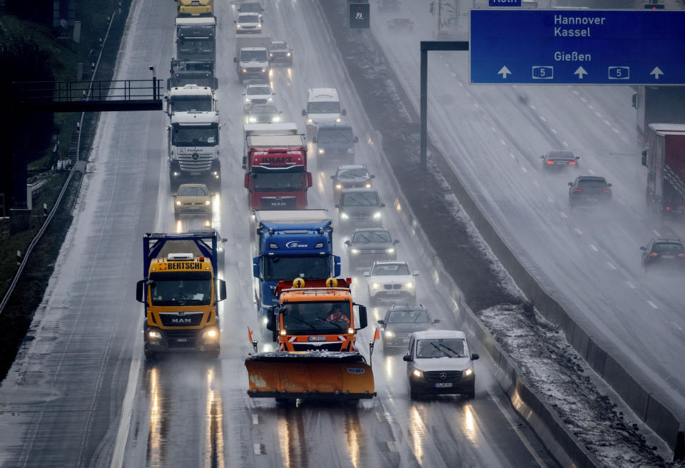 A salt truck drives on the highway as rain sets in combined with low temperatures in Frankfurt, Germany, Wednesday, Jan. 17, 2024. (AP Photo/Michael Probst)