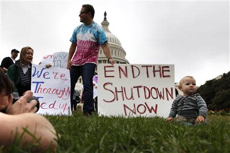 Mason Palmer (R), 10 months old, has his picture taken by his father in front of federal workers demonstrating for an end to the U.S. government shutdown on the west front of the U.S. Capitol in Washington, October 13, 2013. REUTERS/Jonathan Ernst