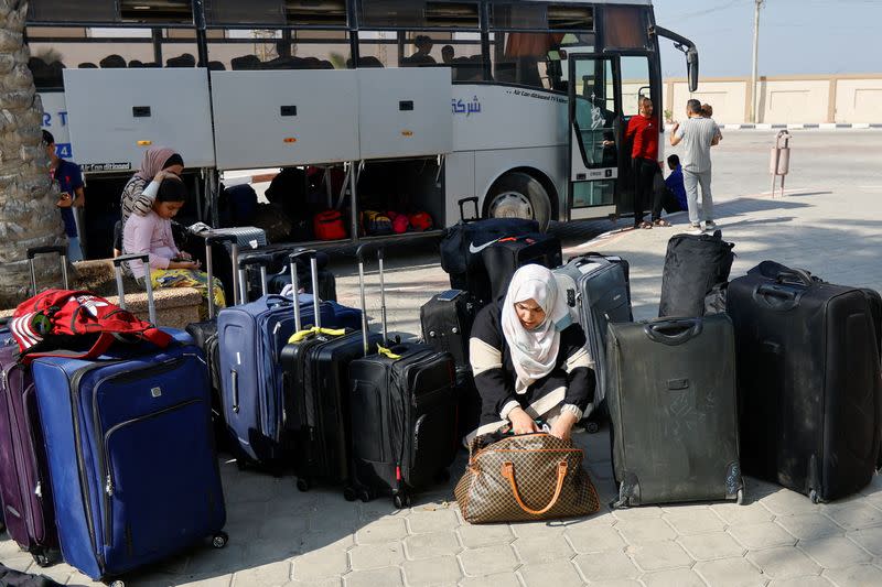 FILE PHOTO: Palestinians holding foreign passports wait for permission to leave Gaza, at the Rafah border crossing with Egypt