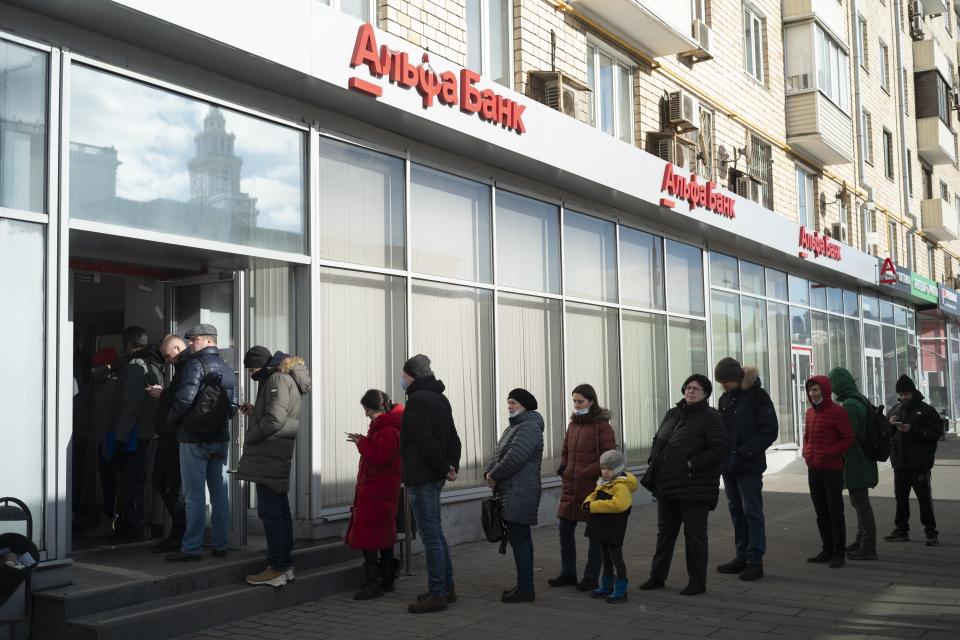 People stand in line to withdraw money from an ATM of Alfa Bank in Moscow, Russia, Sunday, Feb. 27, 2022. Russians flocked to banks and ATMs shortly after Russia launched an attack on Ukraine and the West announced crippling sanctions. (AP Photo)