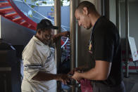 In this Sept. 8, 2018 photo, a nurse checks the blood oxygen saturation levels of dialysis patient Edwin Alvarado before he boards a plane in Vieques, Puerto Rico. Alvarado says he'd love to move to the Puerto Rican mainland and live close to a dialysis clinic, but he has nowhere to stay and cannot afford to leave his home behind in Vieques and find somewhere new to live. (AP Photo/Carlos Giusti)