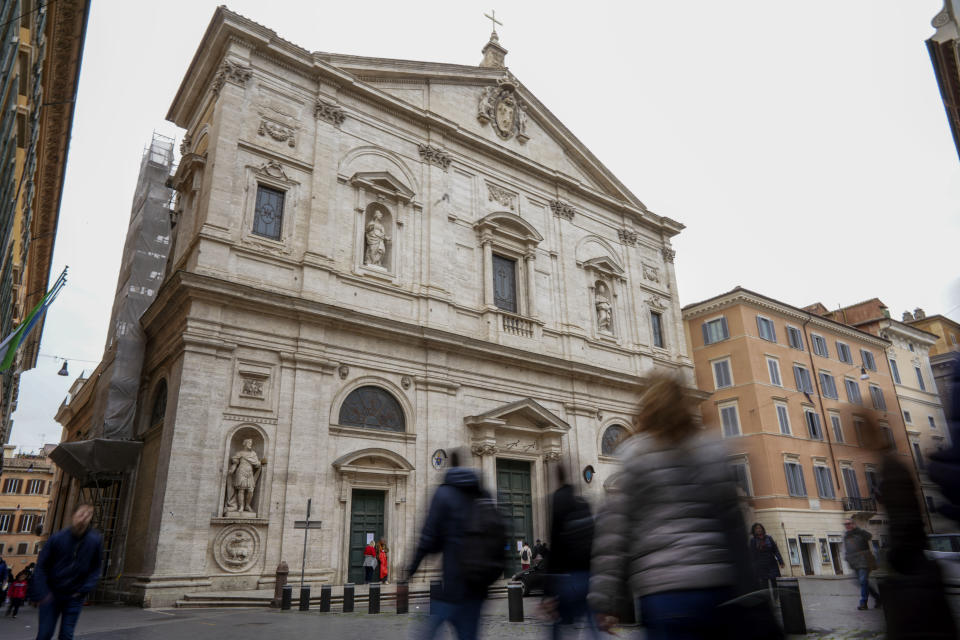 People walk past the St. Louis of the French church in Rome, Sunday, March 1, 2020. The French community church in Rome, St. Louis of the French, closed its doors to the public on Sunday, reportedly after a priest was infected with a new virus. The church in the historic center of Rome is famous for three paintings by the Baroque master Caravaggio, and is a tourist draw. A sign on the door Sunday noted in French that the church had been closed as a precaution by the French Embassy for both Masses and touristic visits until further notice. (AP Photo/Andrew Medichini)