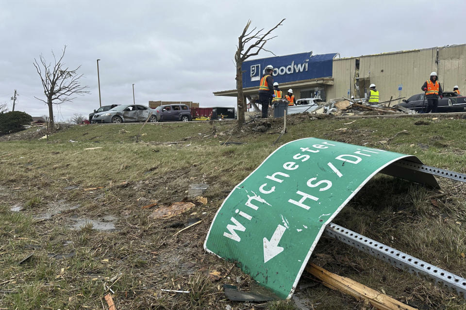 Emergency crews and residents pick up around Winchester, Ind., Friday morning, March 15, 2024, after severe weather hit the area Thursday night. The roof of a Goodwill location off of Indiana Highway 27 was torn off and its walls were shredded. (AP Photo/Isabella Volmert )