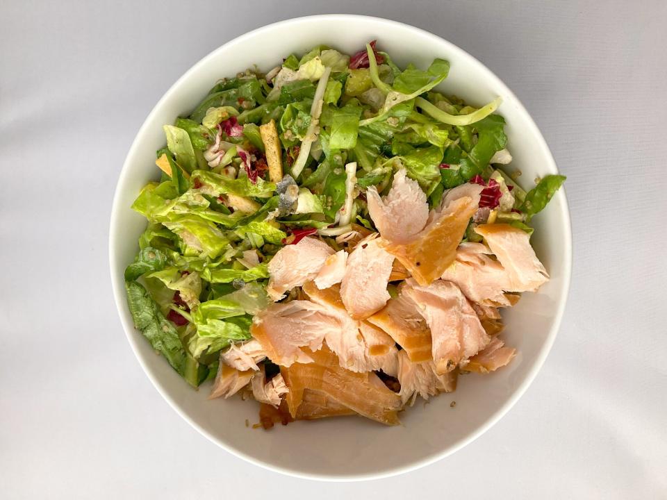a white bowl with salmon and greens