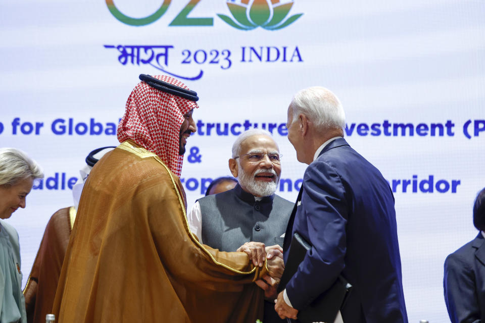 Saudi Arabian Crown Prince Mohammed bin Salman Al Saud, left, and U.S. President Joe Biden, right, shake hands next to Indian Prime Minister Narendra Modi on the day of the G20 summit in New Delhi, India, Sept. 9, 2023. (AP Photo/Evelyn Hockstein, Pool)