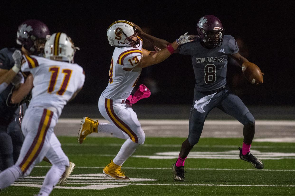 Mt. Vernon’s Nicot Burnett (8) pushes off Gibson Southern’s Adrean Lukema (13) as the Gibson Southern Titans play the Mt. Vernon Wildcats in Mt. Vernon, Ind., Friday evening, Oct. 1, 2021. 