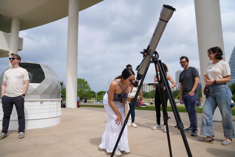 Maria Avila-Franklin looks through a telescope at the Long Center's total solar eclipse viewing party. Avila-Franklin came down from New York City to experience the eclipse in Austin.