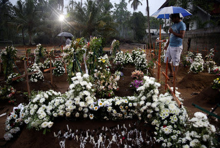 People come to the site of a mass burial to pay their respects to victims of a string of suicide bomb attacks on churches and luxury hotels on Easter Sunday, in Negombo, Sri Lanka April 25, 2019. REUTERS/Athit Perawongmetha