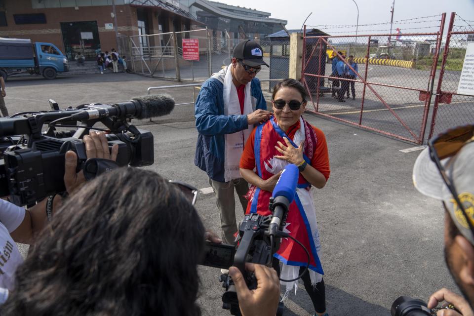 Kim Lal Gautam puts the national flag on Phunjo Lama on her arrival at airport in Kathmandu, Nepal, Sunday, May 26, 2024. Lama scaled the peak in 14.5 hours becoming the fastest female to do so. (AP Photo/Niranjan Shrestha)