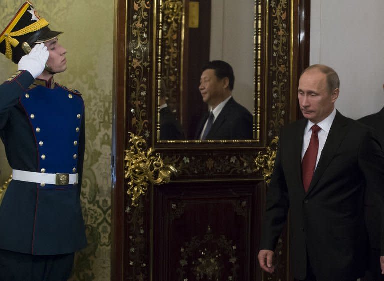 Russia's President Vladimir Putin (L) followed by his Chinese counterpart Xi Jinping (reflected in the mirror) enters a hall before their talks in the Grand Kremlin Palace in Moscow, on March 22, 2013