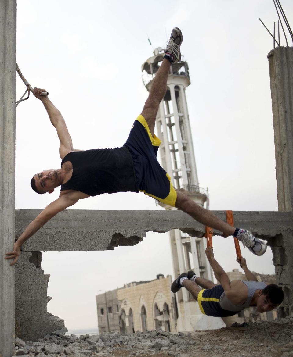 Palestinian group, Bar Palestine, take part in street exercises amid the destruction in Gaza City on August 3, 2015. Street workout, that is still new to Gaza, is a growing sport across the world with annual competitions and events.