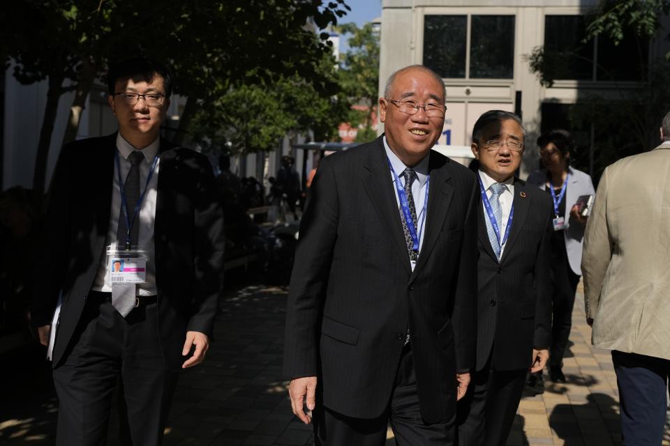 Xie Zhenhua, China special envoy for climate, center, and Liu Zhenmin, former vice foreign minister of China, right, walk through the COP28 U.N. Climate Summit, Sunday, Dec. 10, 2023, in Dubai, United Arab Emirates. (AP Photo/Rafiq Maqbool)