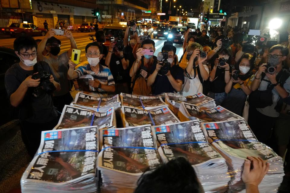 People gather to buy the last issue of Apple Daily as it arrives at a newspaper booth in Hong Kong, early Thursday (AP)