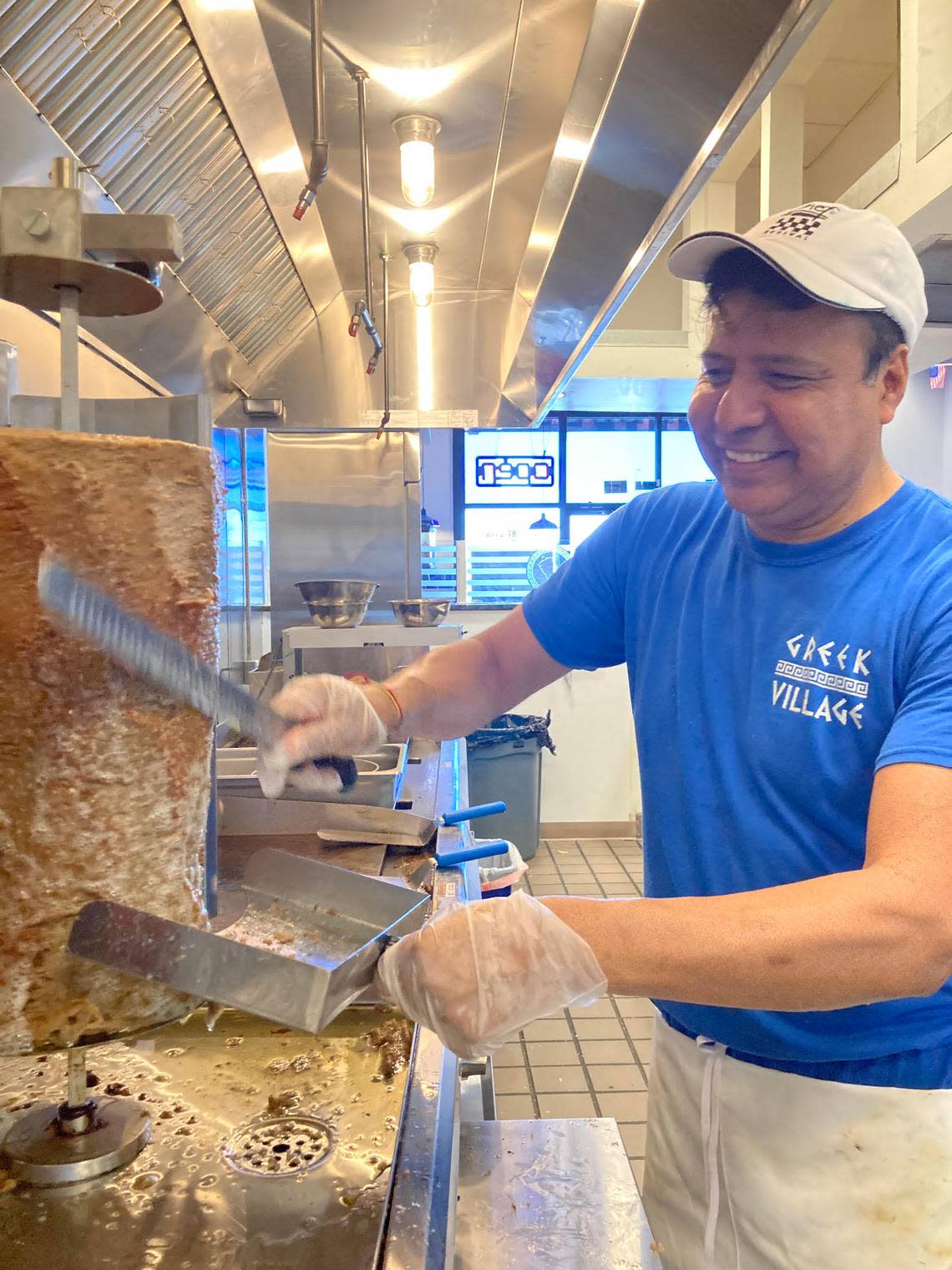 Nabor Gutierrez, chef, manager and owner Olympia Gyros in Warner Robins, carves meat off the gyro spit.