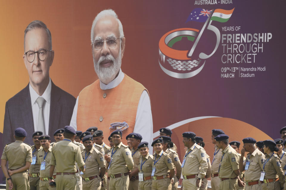 Indian policemen stand in front of a hoarding featuring Australian Prime Minister Anthony Albanese and Indian Prime Minister Narendra Modi during a practice session before fourth test cricket match between India and Australia, in Ahmedabad, India, Tuesday, March 7, 2023. (AP Photo/Ajit Solanki)