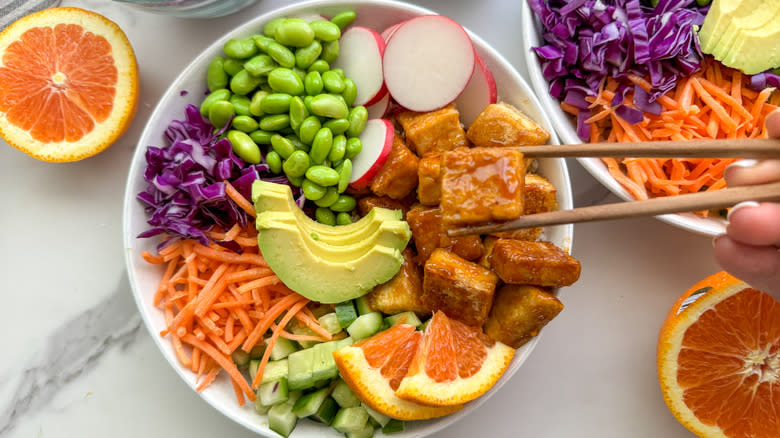 orange tofu rice bowl with colorful vegetables