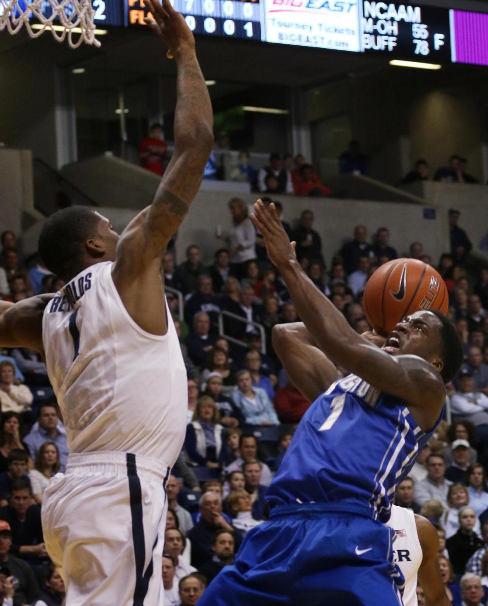 Creighton's Austin Chatman shoots past Xavier's Jalen Reynolds during the first half of an NCAA college basketball game in Cincinnati Saturday, March 1, 2014. (AP Photo/Tom Uhlman)