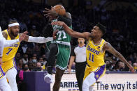 Boston Celtics guard Dennis Schröder (71) is defended by Los Angeles Lakers guard Malik Monk (11) and forward Carmelo Anthony (7) during the first half of an NBA basketball game Tuesday, Dec. 7, 2021, in Los Angeles. (AP Photo/Marcio Jose Sanchez)