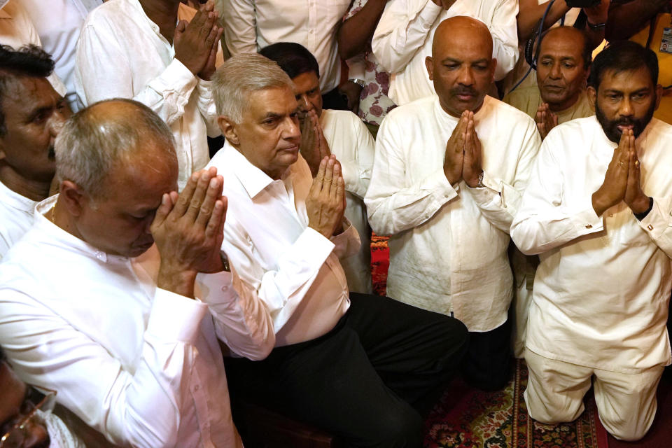 Sri Lanka's new prime minister Ranil Wickremesinghe, second left, takes part in religious observances at a temple in Colombo, Sri Lanka, Thursday, May 12, 2022. Five-time former Sri Lankan Prime Minister Ranil Wickremesinghe was reappointed Thursday in an effort to bring stability to the island nation, engulfed in a political and economic crisis.(AP Photo/Eranga Jayawardena)