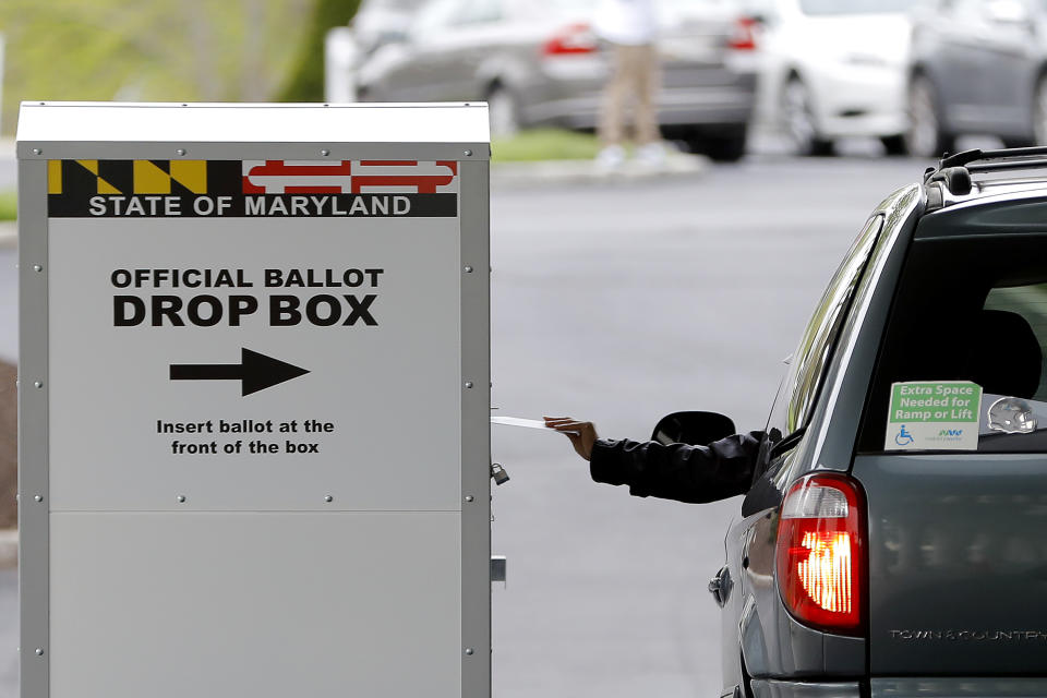 A motorist drops off a mail-in ballot outside of a voting center during the 7th Congressional District special election, Tuesday, April 28, 2020, in Windsor Mill, Md. The election to fill a seat left open by the death last October of Congressman Elijah Cummings has been dramatically reshaped by the coronavirus outbreak. (AP Photo/Julio Cortez)