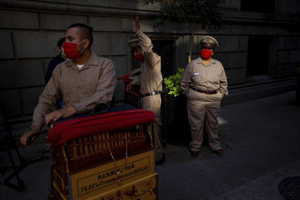 Organ grinders who make money from tips wait for donated groceries in Mexico City, Thursday, June 4, 2020. CADENA, a non-profit, civil organization dedicated to assisting during emergencies and disasters around the world, delivered groceries to hundreds of organ grinders who have lost their source of income amid restrictions to curb the new coronavirus. (AP Photo/Fernando Llano)