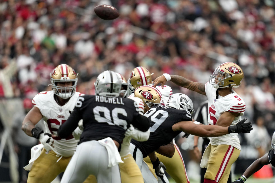 San Francisco 49ers quarterback Trey Lance (5) throws under pressure from Las Vegas Raiders defensive end Jordan Willis (99) during the first half of an NFL preseason football game, Sunday, Aug. 13, 2023, in Las Vegas. (AP Photo/John Locher)