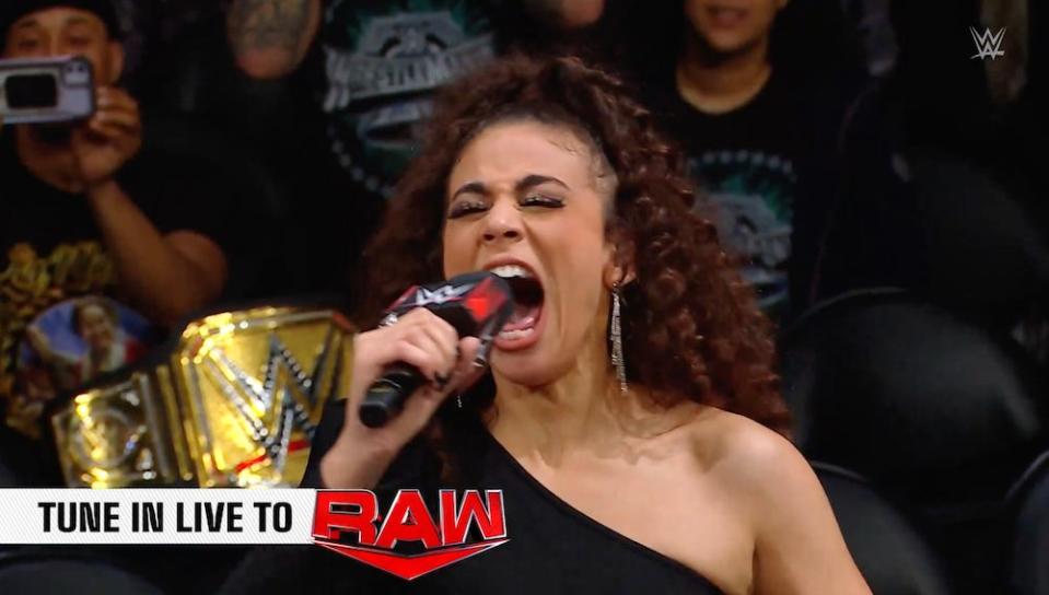 WWE announcer Samanthe Irvin, screaming into a microphone, introduces Cody Rhodes during Monday Night RAW on April 8, 2024.