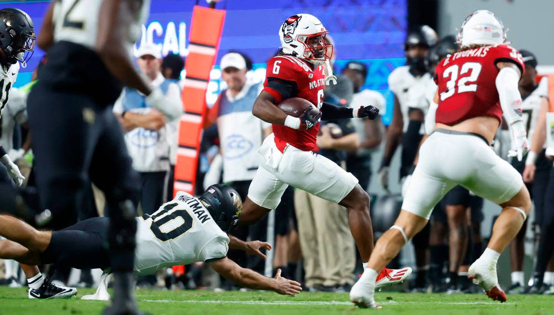 N.C. State safety Jakeen Harris (6) returns an interception past Wake Forest quarterback Sam Hartman (10) during the first half of N.C. State’s game against Wake Forest at Carter-Finley Stadium in Raleigh, N.C., Saturday, Nov. 5, 2022.