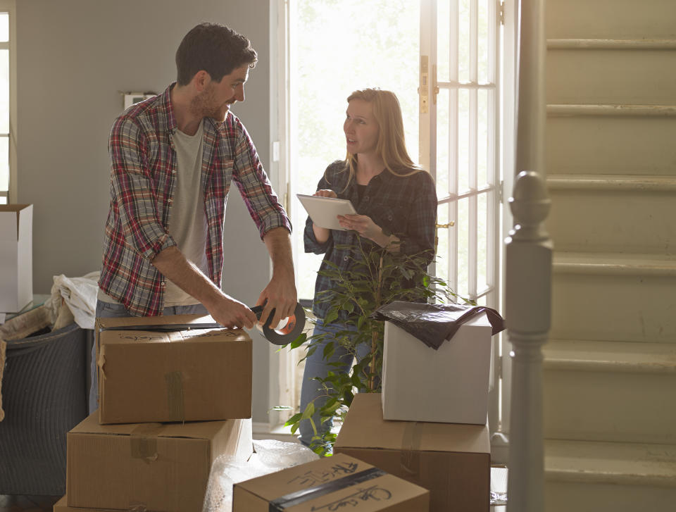 Young professional couple are moving home they have a checklist on tablet computer.