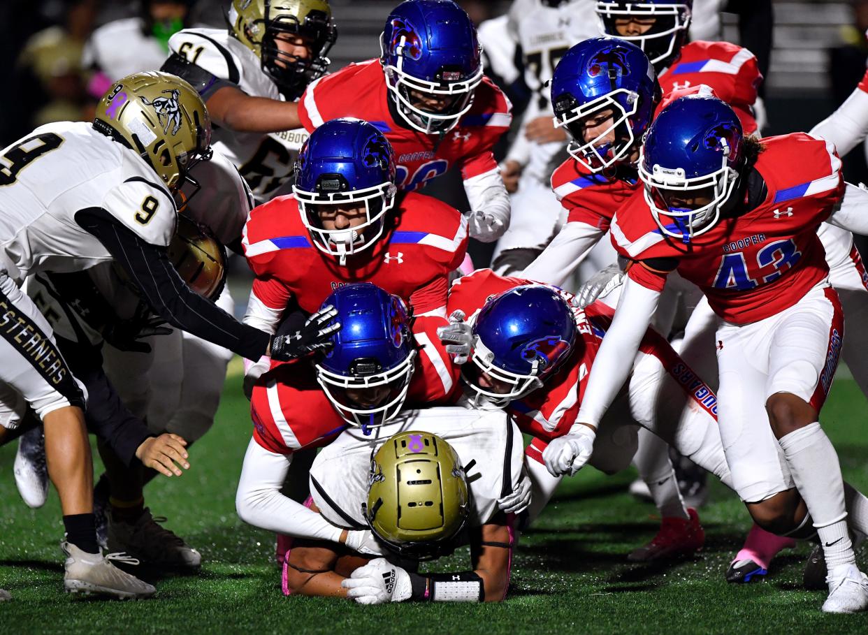 Lubbock High running back Zeke Rodriquez is piled on by Abilene Cooper defenders during Friday's game at Shotwell Stadium.