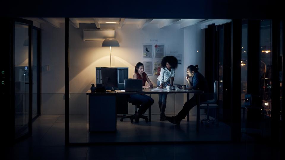 Full length shot of three young creative businesspeople meeting in their office at night.