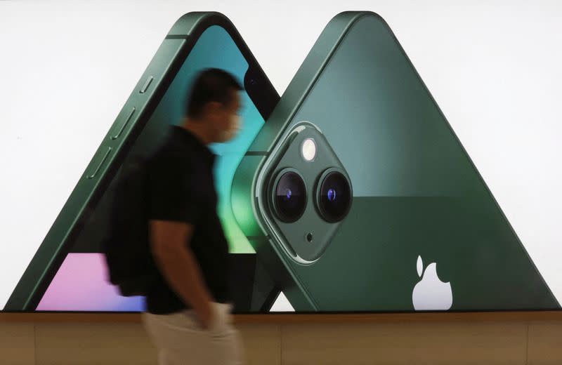 FILE PHOTO: A customer passes an Apple iPhone 13 advertisement at an Apple shop in Singapore