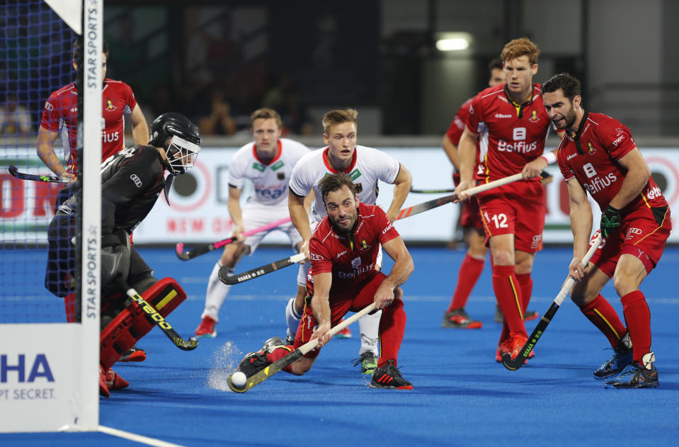 Belgium's Sebastien Dockier, center, takes control of the ball to save a goal during the Men's Hockey World Cup quarterfinal match between Belgium and Germany at the Kalinga Stadium in Bhubaneswar, India, Thursday, Dec. 13, 2018. (AP Photo/Aijaz Rahi)