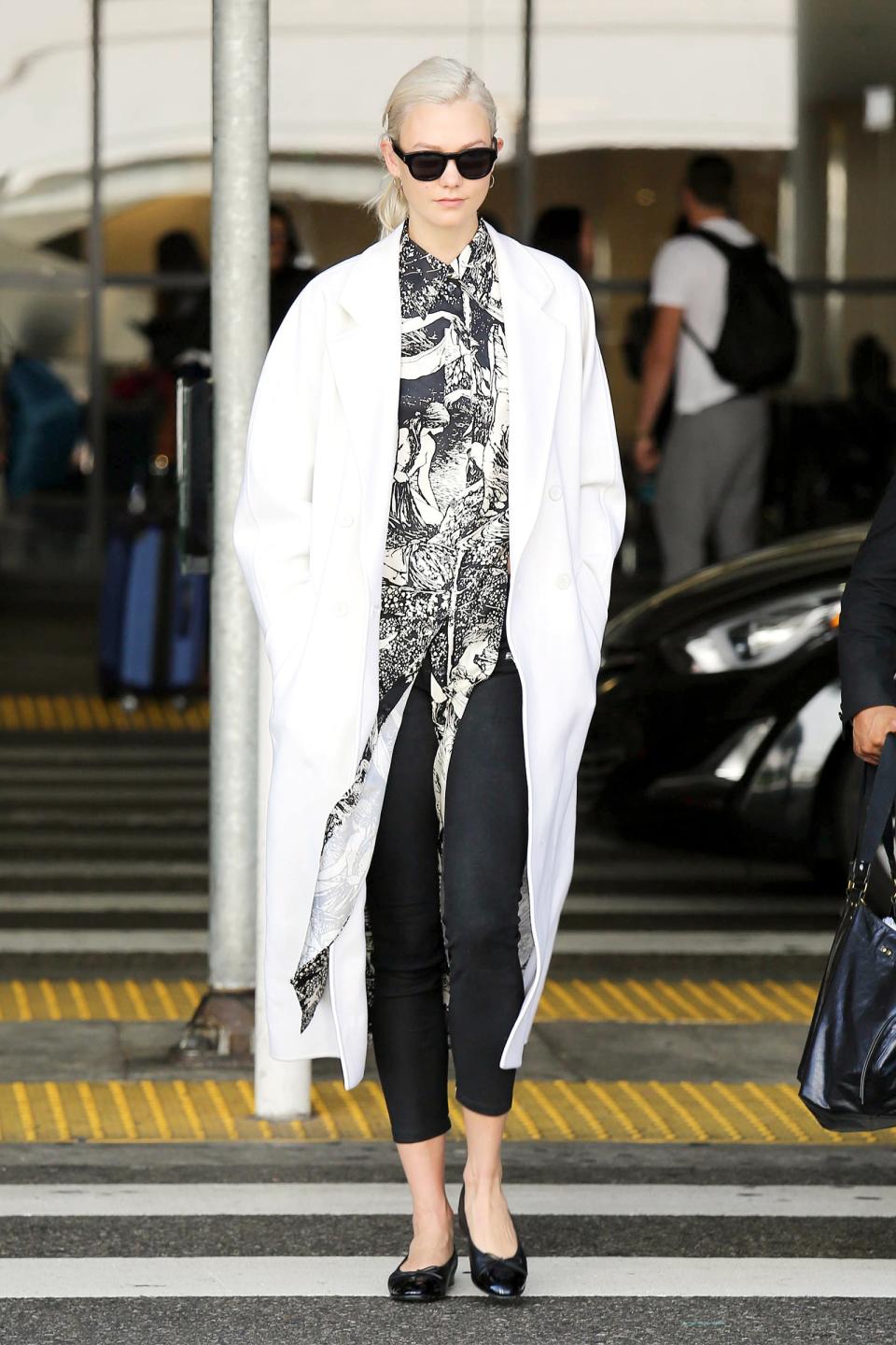 Make a Karlie Kloss–style arrival in a printed top and black pants.