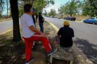 Men wait near vehicles queuing up in an attempt to refuel at a gas station of the state oil company PDVSA in Ciudad Guayana, Venezuela, May 17, 2019. REUTERS/William Urdaneta NO RESALES. NO ARCHIVE.