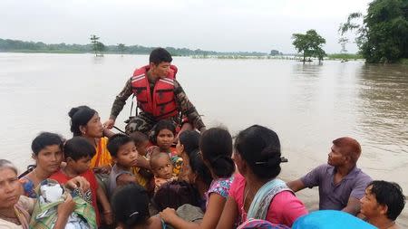 An army officer assists flood victims in Jhapa, Nepal, July 24, 2016. Picture taken July 24, 2016. Nepalese Army/Handout via REUTERS